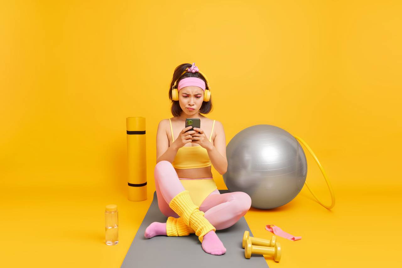 Wayhomestudio Zensina Sosredotocennaa Na Displee Smartfona Ispol Zuet Sportivnoe Snarazenie Odetoe V Sportivnuu Odezdu